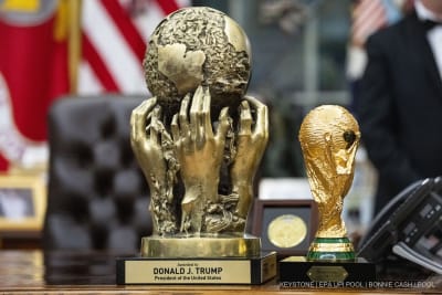 Der FIFA-Friedenspreis (links), den US-Präsident Donald Trump bei der Auslosung der Weltmeisterschaft 2025 bekommen hat, und der FIFA-Weltmeisterschaftspokal (rechts) stehen am 6. Dezember 2025 auf dem Resolute Desk im Oval Office des Weißen Hauses in Washington, DC, USA.