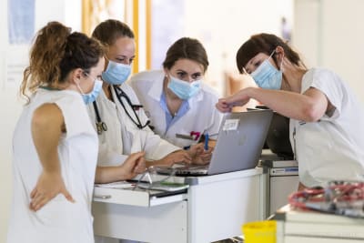 Aerztinnen und Pflegende besprichen sich in einem Huddle, der spezialisierten Kurzsitzung, ueber die anstehenden Patientenbesuche auf der Abteilung fuer COVID-Patienten im HFR Freiburg Kantonsspital, am Donnerstag, 26. November 2020 in Fribourg.