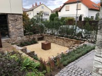 Garten mit Natursteinmauer und Bepflanzung