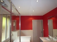 Badezimmer mit weißer Spanndecke Leuchten und rote Wände