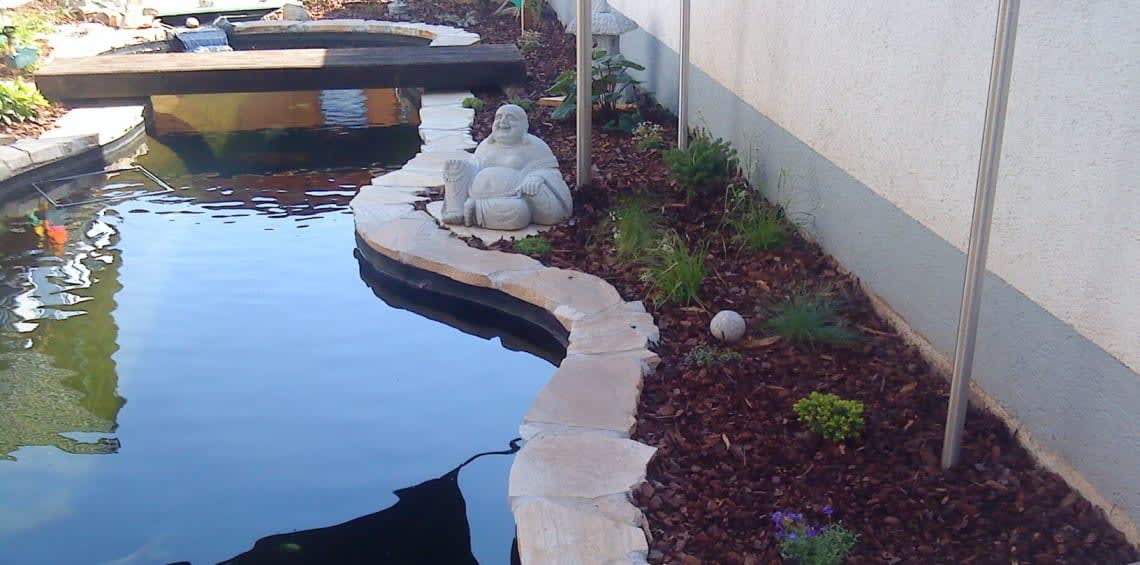 Gartenanlage mit Teich und Buddha Figur