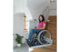 Frau in einem Rollstuhl nutzt Plattfromlift