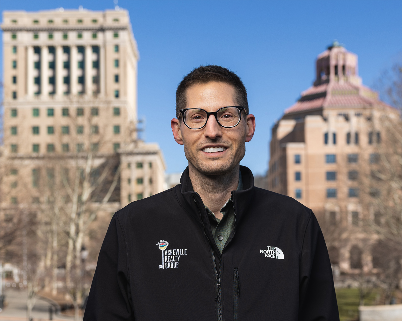 Asheville Real Estate Agent in front of two historic building in downtown Asheville, NC