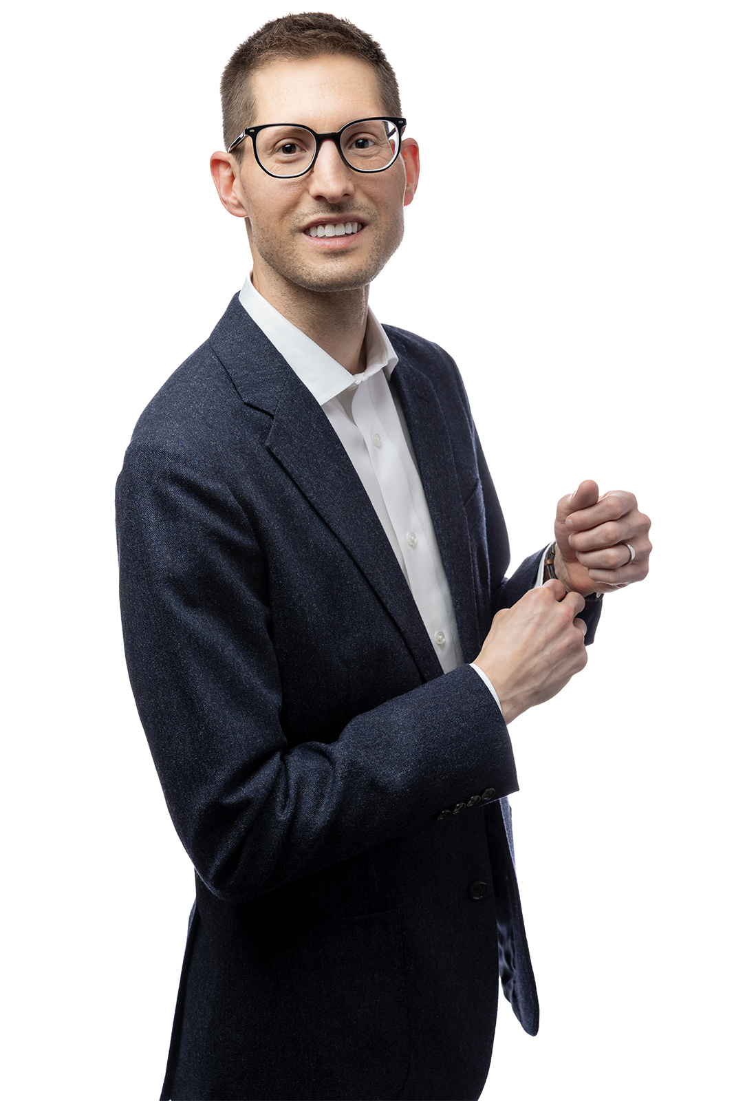 Man in dark blue suit standing in front of a white background