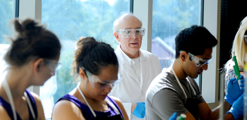 Professor Dennis Merat with a group of student in a chemistry class