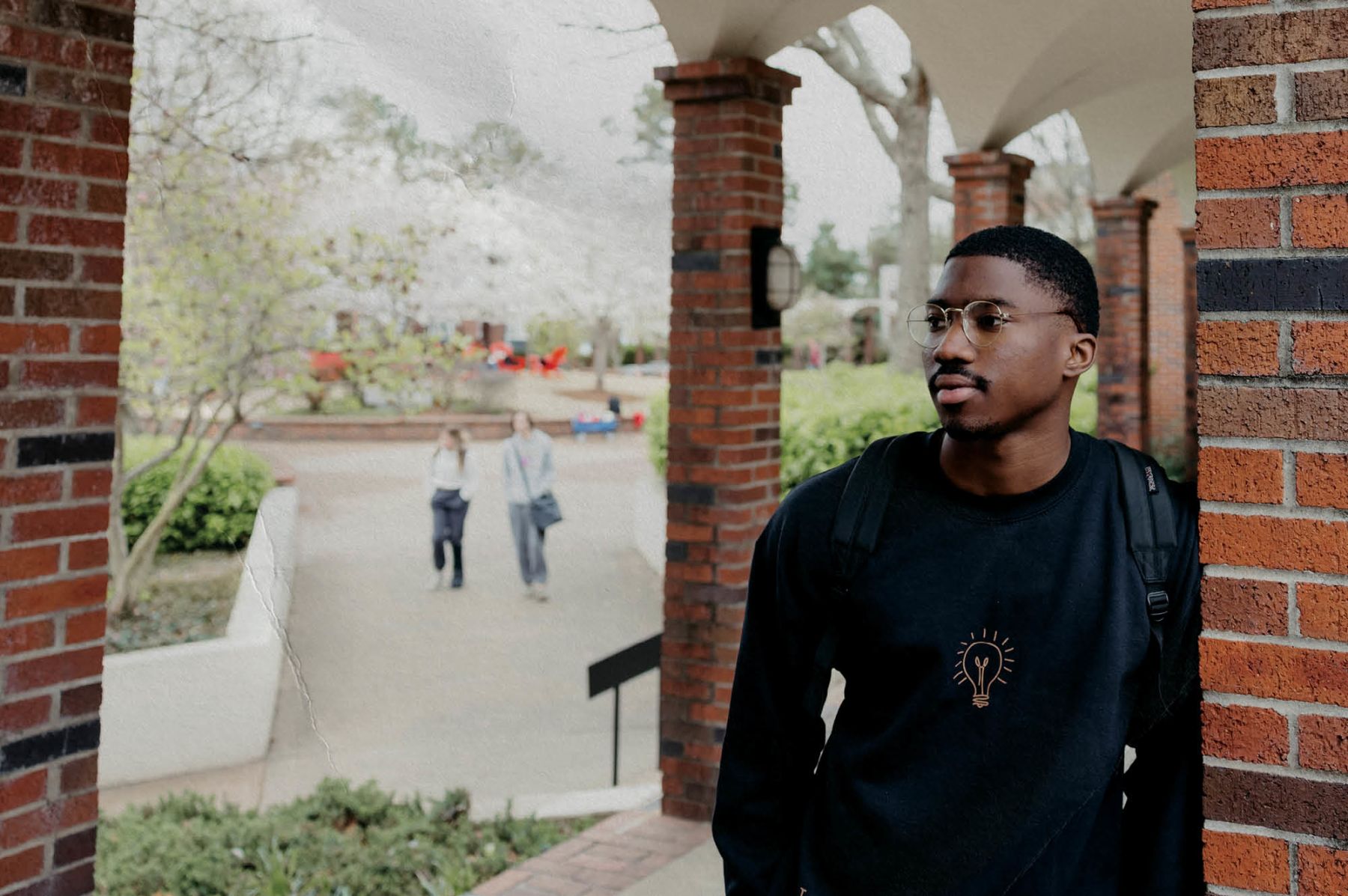 CBU Student standing in arches near the quad.