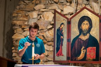 A CBU student lighting a candle for worship Religion & Philosophy