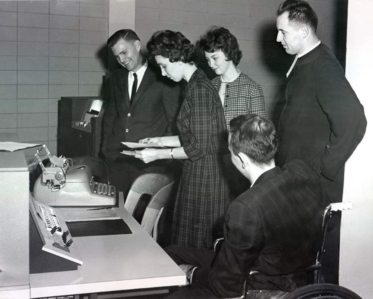 people looking at a type machine