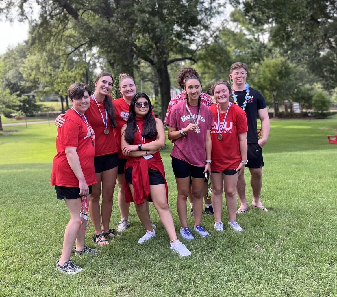 A group of honors students together posing together as a group with their medals and ribbons,