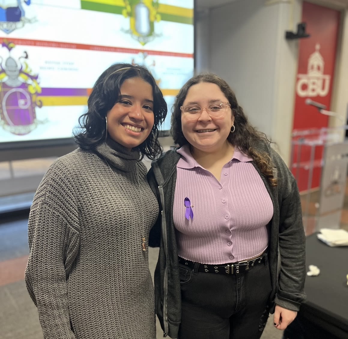 Two honors students standing infront of their power point presentation.