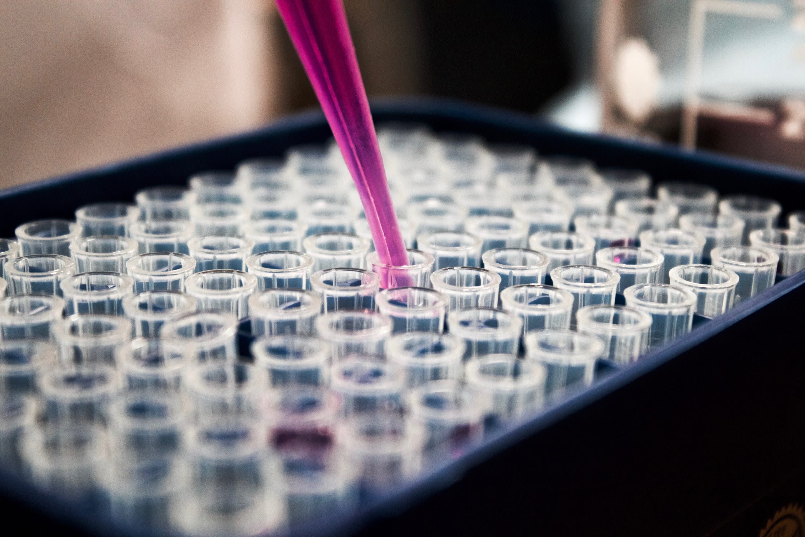 Biochemistry lab worker filling vials for testing