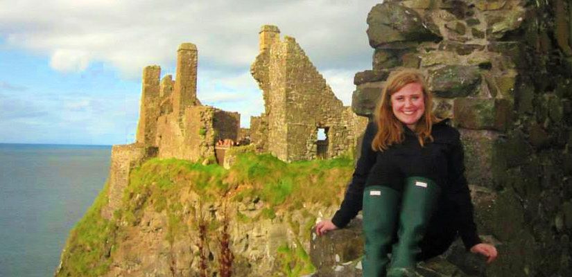 Students at a cliffside stone ruin