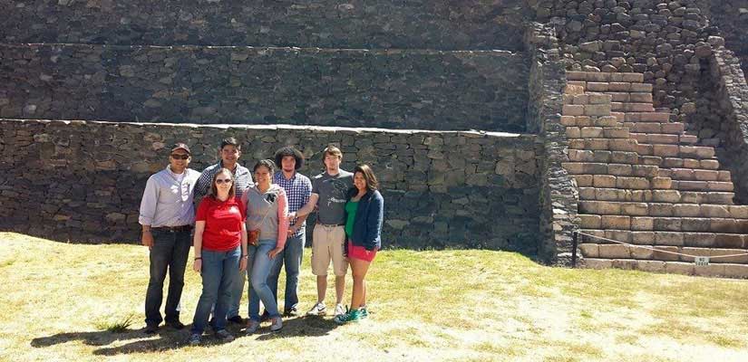Students standing in front of stone ruins