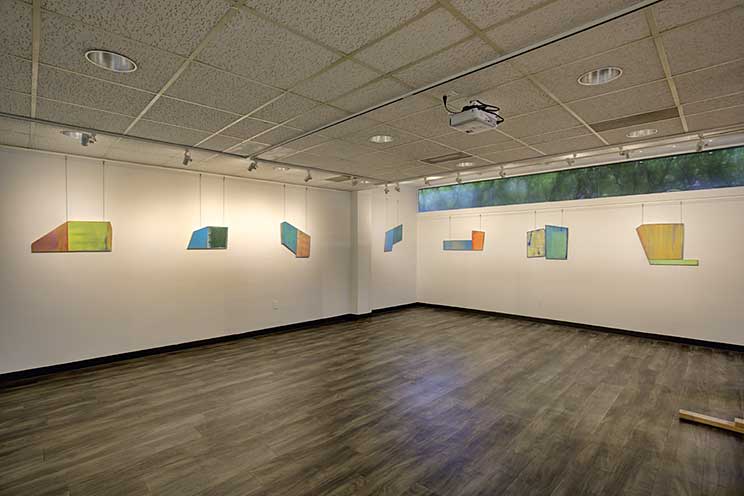 two walls of abstract paintings