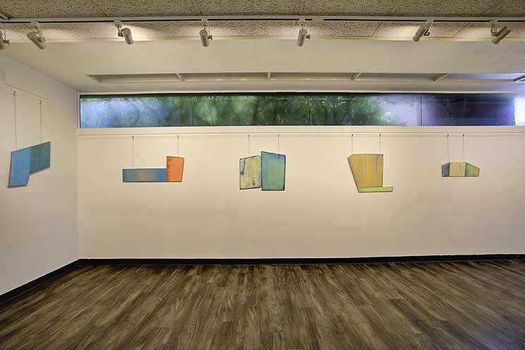 a wall of abstract paintings