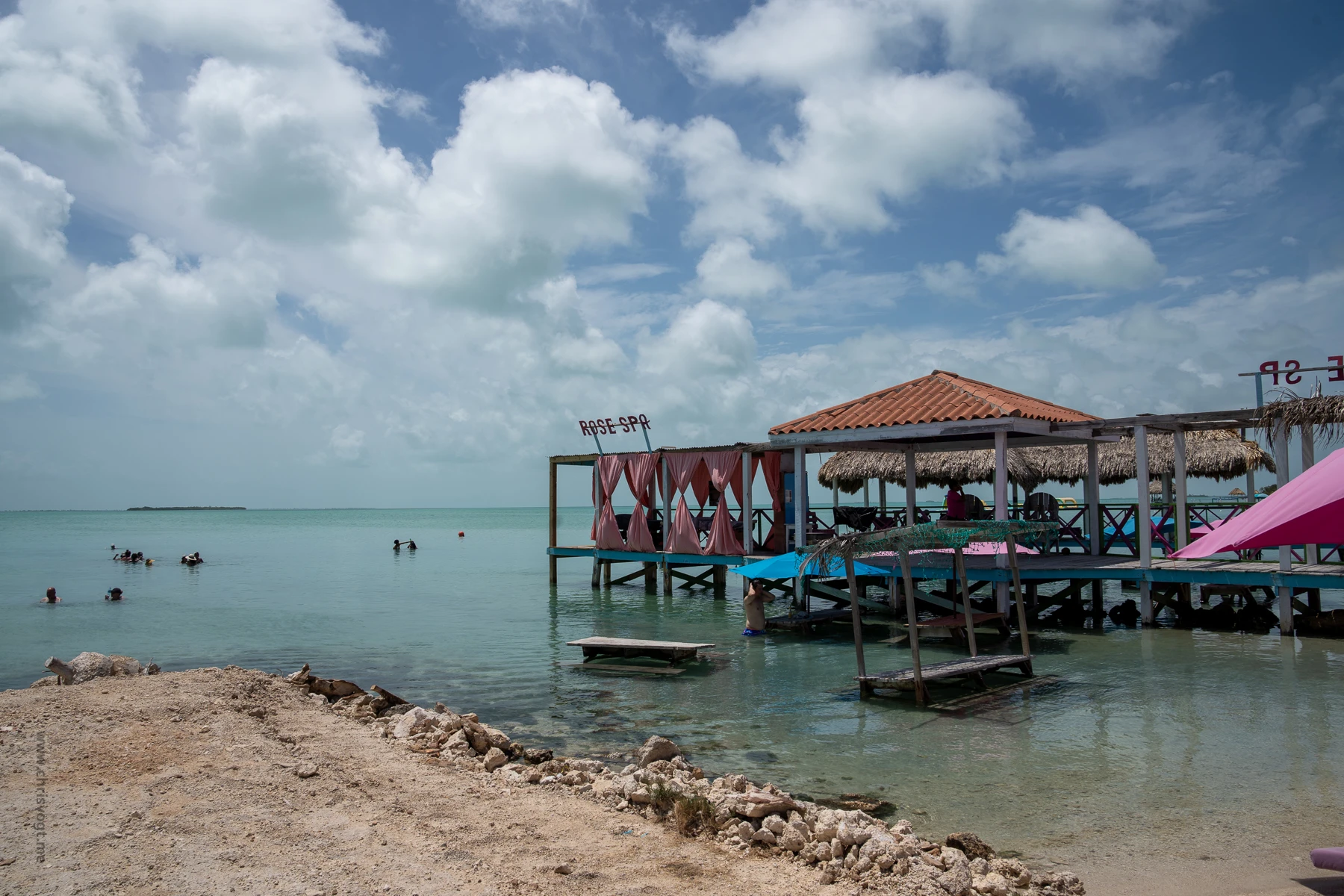 A view of the water near Rose Spa at Secret Beach, and people snorkeling in the distance.