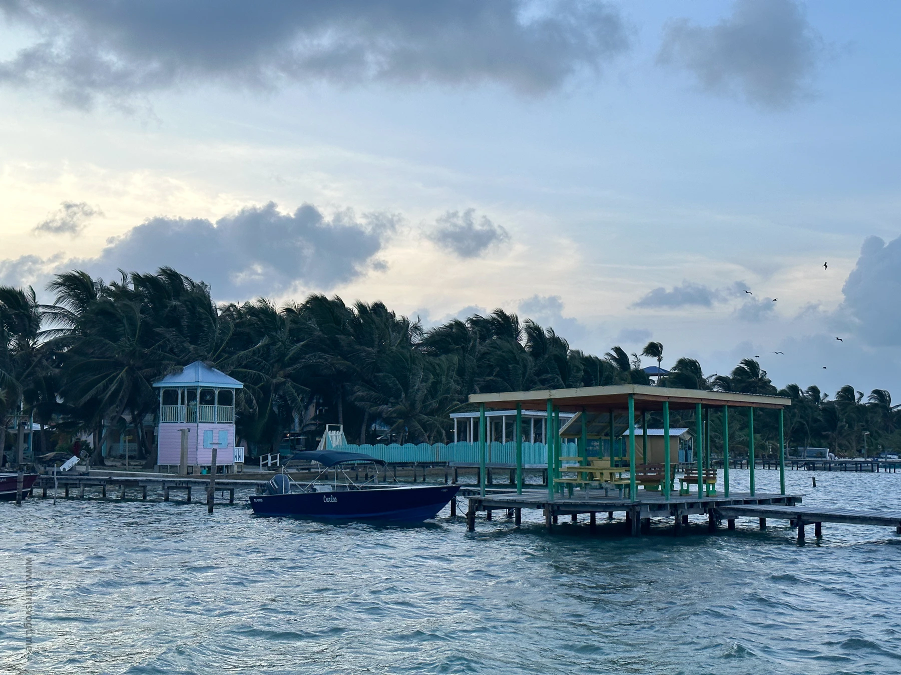 A shot of a pier and a boat at Caye Caulker, Belize.