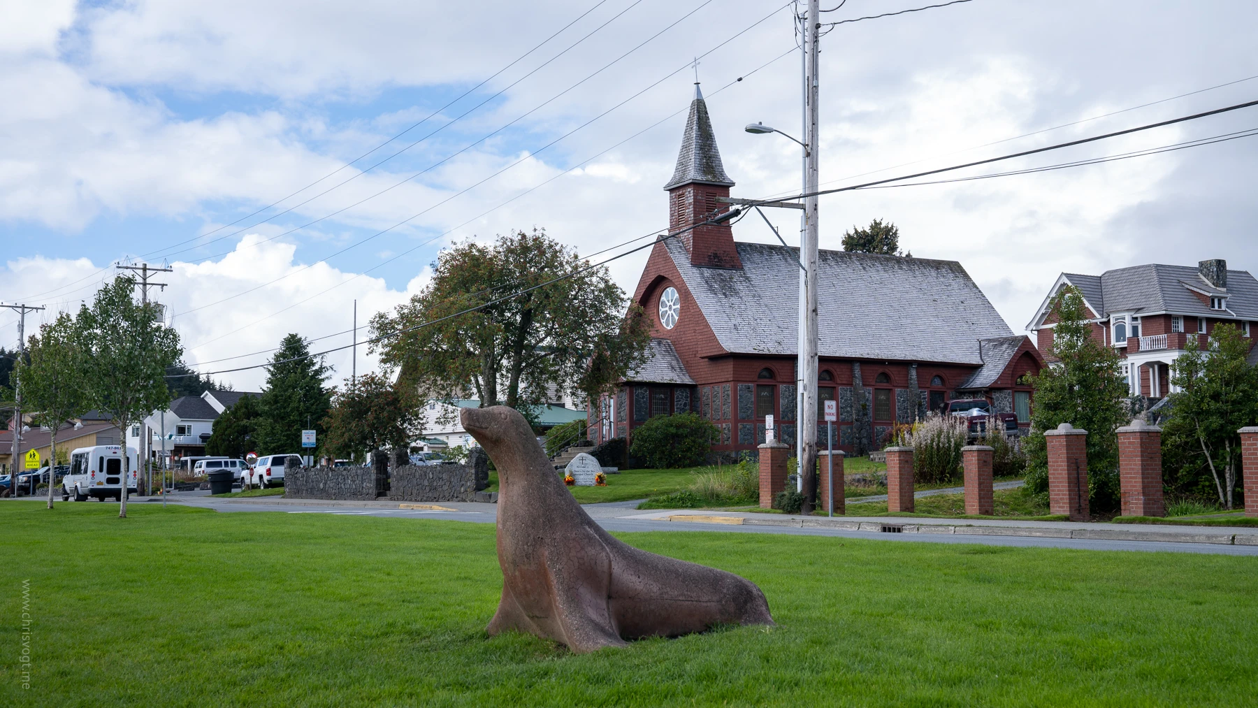 A seal statue in front of a red brich church in Sitka, Alaska