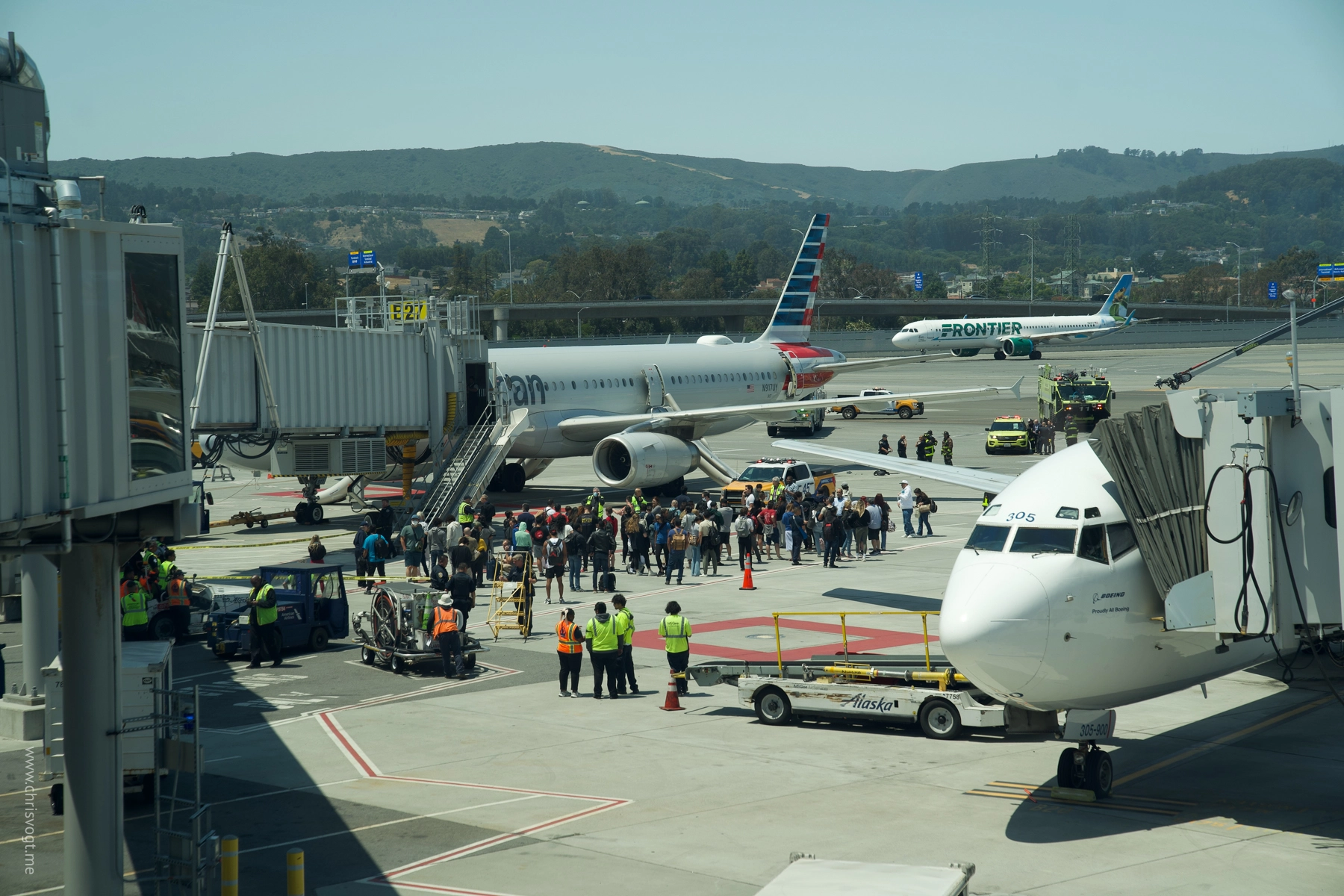 AA 2045 on July 12, 2024. People in the back of the plane slid down the emergency slides to evacuate. Firefighters gathered around a burned backpack in the background.
