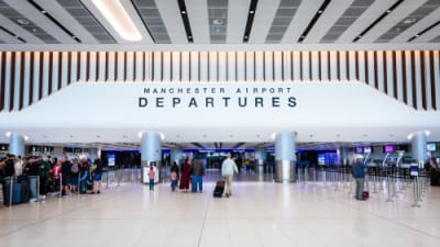 _Air passengers and travellers walking through the departure lounge at Terminal 2 of Manchester Airport.png