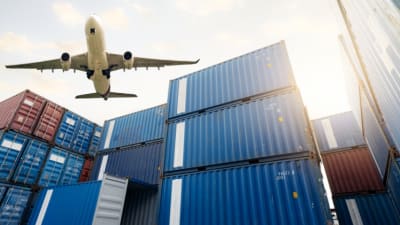 Cargo airplane flying above stack of logistic containers. .png