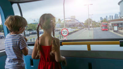 Two children passengers are looking out the bus window in the UK.png