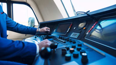 Cockpit view of train dashboard and driver. .png