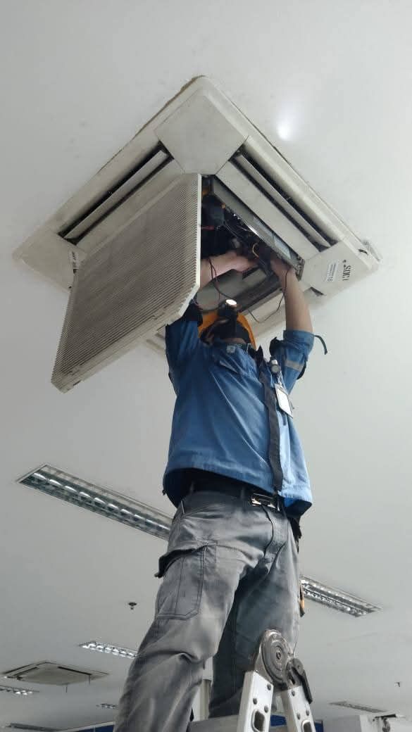 Technician servicing an air conditioning unit