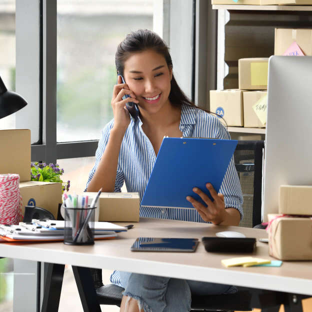 Inhaberin eines Kleinunternehmens telefoniert in ihrem Büro mit einem Dect-Telefon.