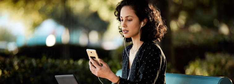 Frau telefoniert per Handy im Park