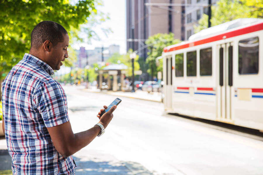Mann greift unterwegs vom Handy aus auf seine Faxe zu