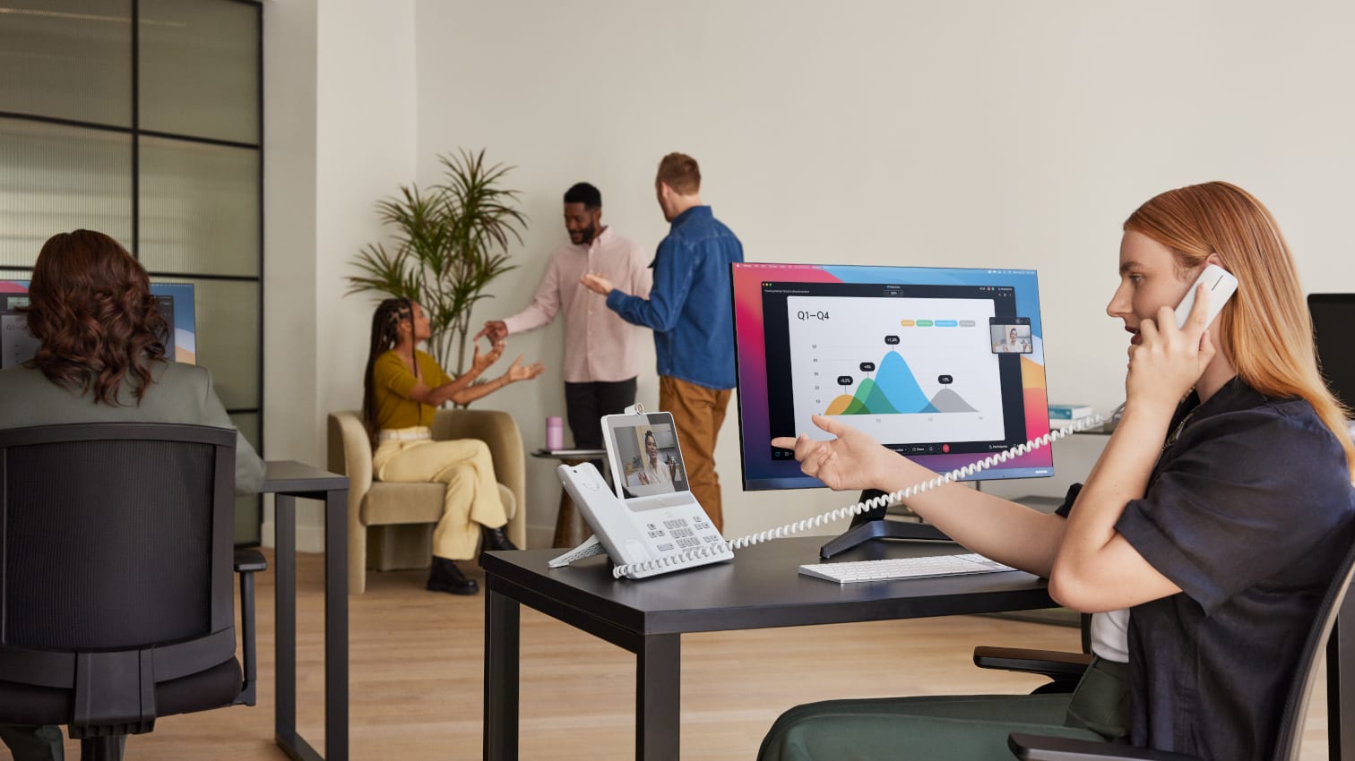 Frau, die am Schreibtisch sitzt und die Bildtelefonie mit einem Telefon nutzt