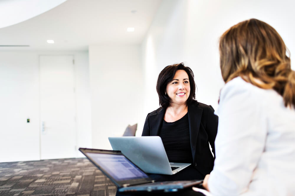 Frauen unterhalten sich am Arbeitsplatz