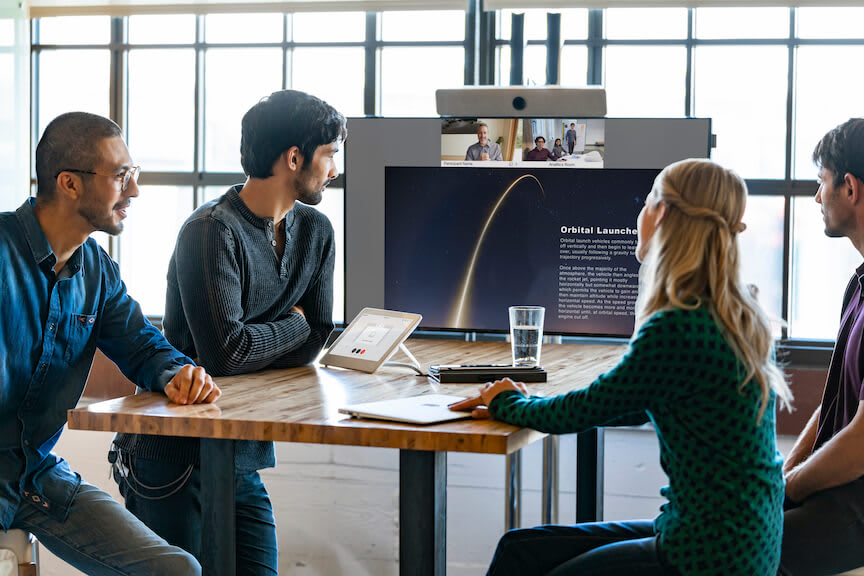 Ein Team arbeitet hybrid mit Teammitgliedern im Remote-Setting zusammen