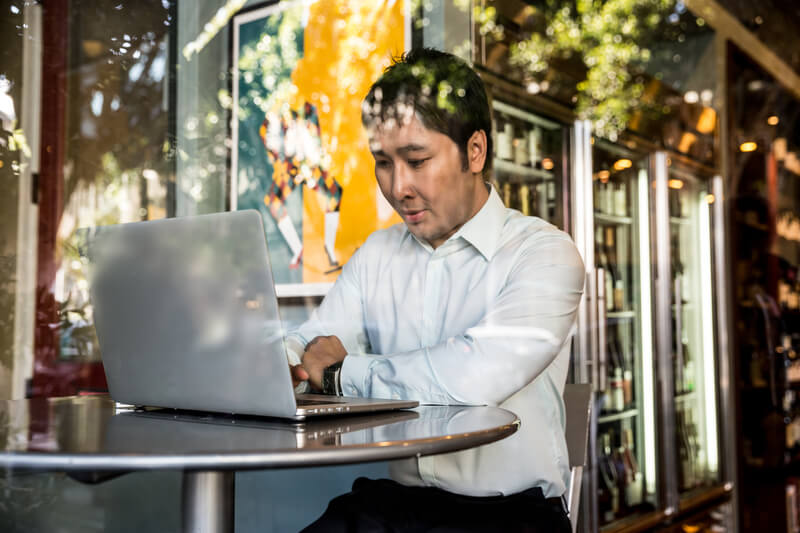 Ein Mann befindet sich mit seinem Laptop an einem öffentlichen Arbeitsplatz