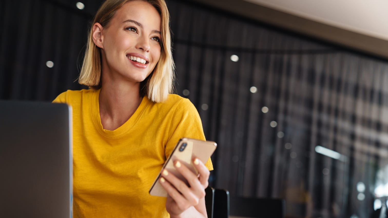 Frau, die ein Smartphone in der Hand hält und lächelt