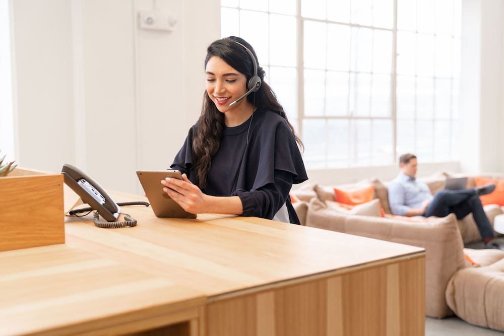 Frau arbeitet im Wohnzimmer mit digitalen Devices