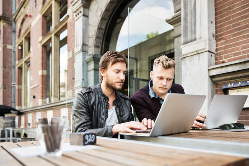 Zwei Männer arbeiten zusammen im Remote Office