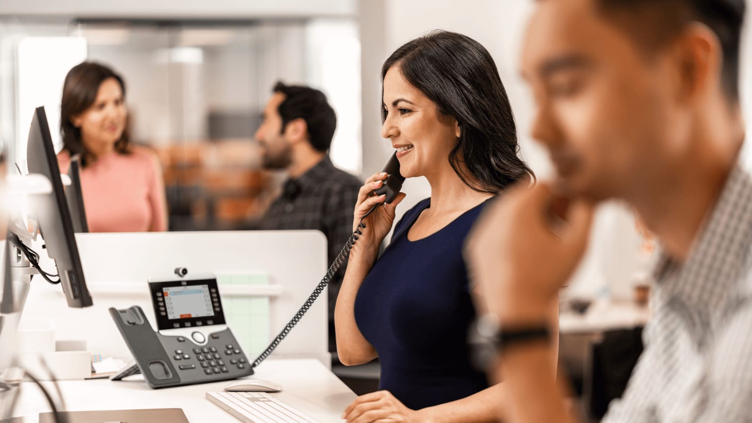 Frau telefoniert mit IP-Telefon im Büro