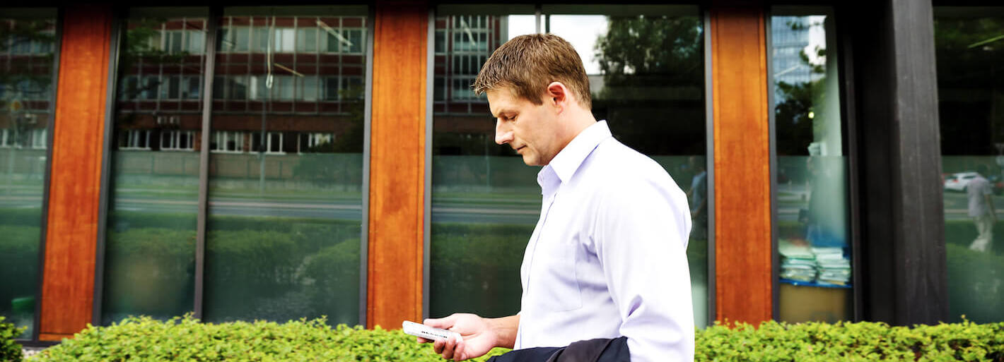 Mann auf Geschäftsreise mit Smartphone in der Hand