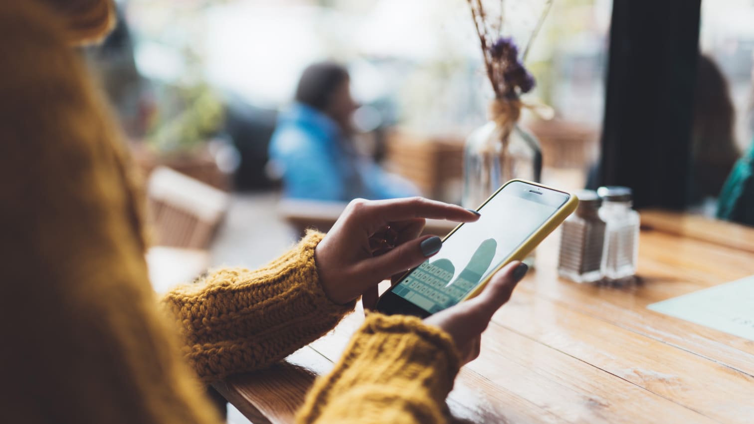 Frau, die im Büro auf ihrem Handy scrollt
