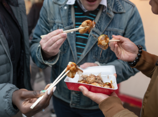 People eating street food with chopsticks