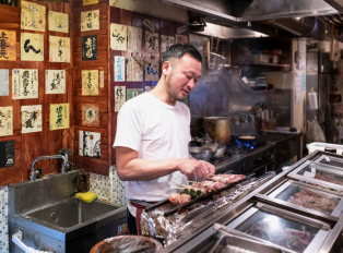 Person cooking Japanese food in a local Izakaya