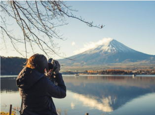 Tourist taking a photo of Mount Fuji from Lake Ashi, Ja