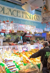 Tourists browsing the seafood options at Pike Place market in Seattle 