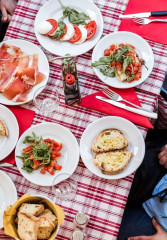 Tourist dining al fresco with a local on a food tour in Italy