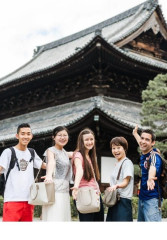 Group of tourists posing with their local guide at a popular temple in Kyoto