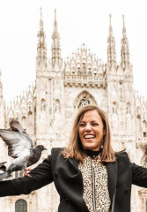 Tourist feeding pigeons in front of Duomo di Milano