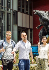 Group of tourists standing in front of the Godzilla statue in Osaka with a local guide