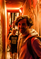 Tourist walking down a neon-lit alleyway on a night out in Amsterdam